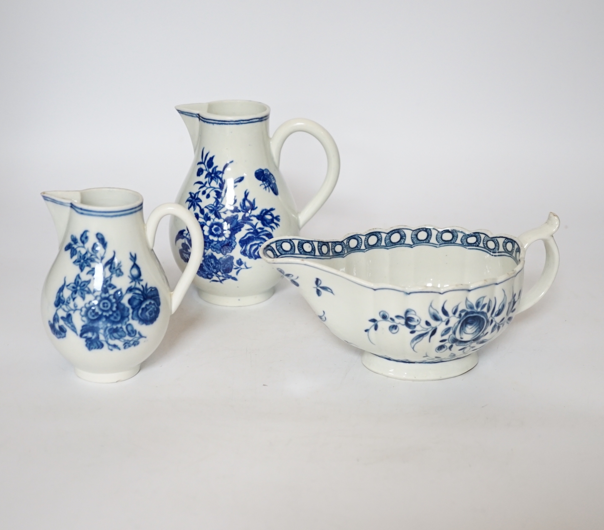 A Worcester rose pattern sauceboat c.1770 and two three flowers pattern milk jugs, largest 18cm wide